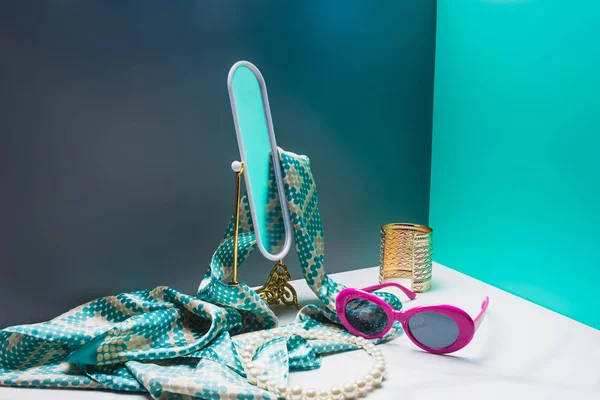 Espejo de juguete con bufanda de seda y accesorios elegantes en la habitación azul en miniatura - foto de stock