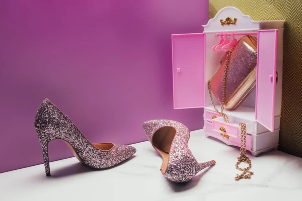 Guarda-roupa de brinquedo com tamanho real salto alto brilhante e bolsa em miniatura quarto rosa — Fotografia de Stock