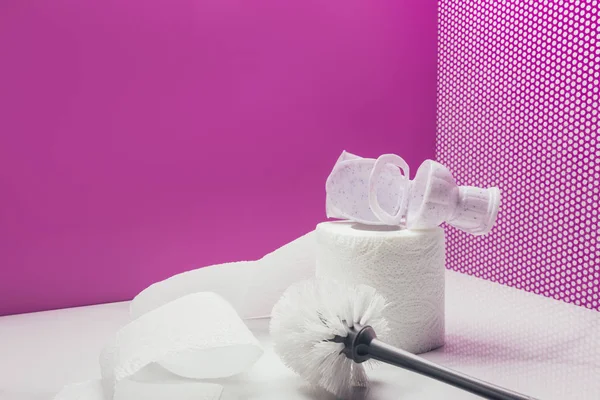 WC jouet en plastique avec brosse de toilette de taille réelle et rouleau de papier dans la salle miniature rose — Photo de stock