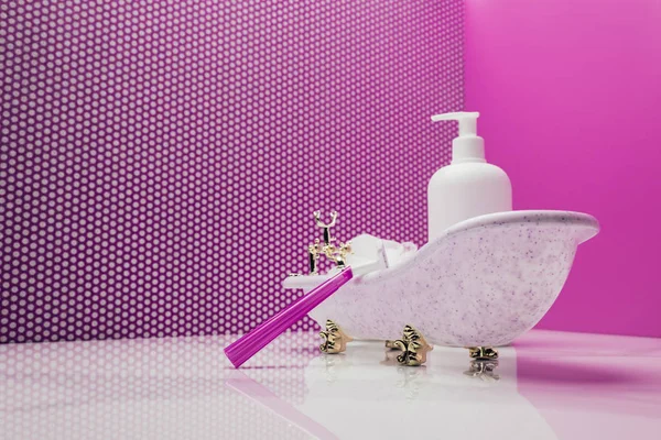 Игрушечная ванна с бритвой реального размера и лосьоном бутылка в розовой комнате миниатюра — стоковое фото