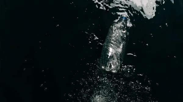 Vista superior de la botella de plástico en el agua, concepto de protección ecológica - foto de stock