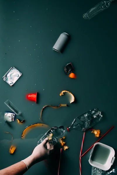 Partial view of man in latex glove cleaning water from trash, ecology protection concept — Stock Photo