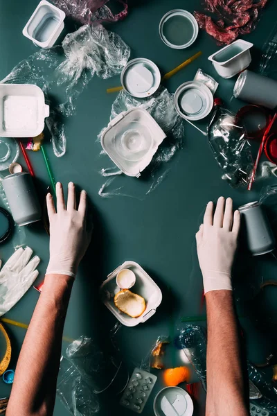 Partial view of man in latex gloves cleaning water from trash, ecology protection concept — Stock Photo