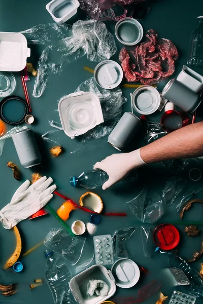 Partial view of man in latex glove cleaning water from trash, ecology protection concept — Stock Photo