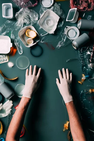 Partial view of man in latex gloves cleaning water from trash, ecology protection concept — Stock Photo