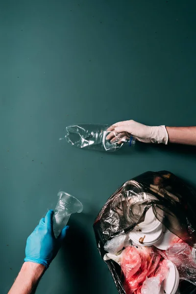 Recortado tiro de hombre y mujer en guantes de látex limpieza de agua de la basura, concepto de protección ecológica - foto de stock