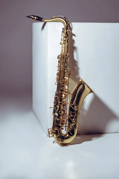 Nahaufnahme eines einzigen glänzenden Profi-Saxophons auf Grau — Stockfoto