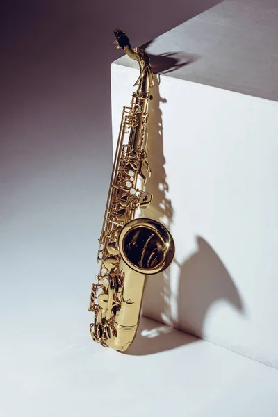 Vista de cerca del saxofón profesional brillante único en gris - foto de stock