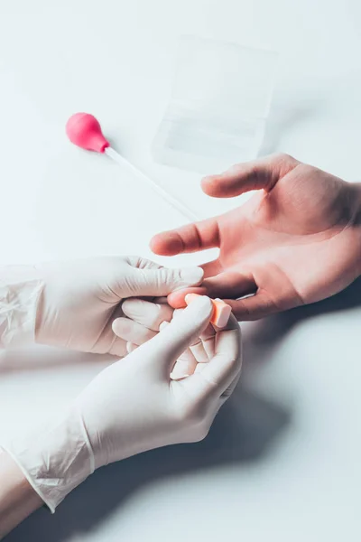 Tiro recortado do doutor que toma o sangue do paciente para o exame na mesa branca — Fotografia de Stock