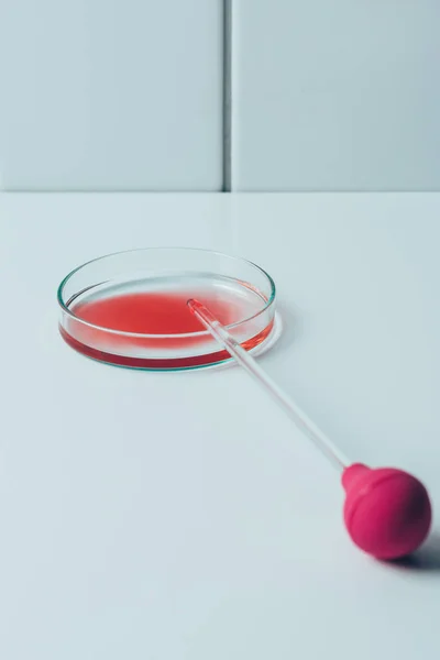 Medical pipette and petri dish with blood on white table — Stock Photo