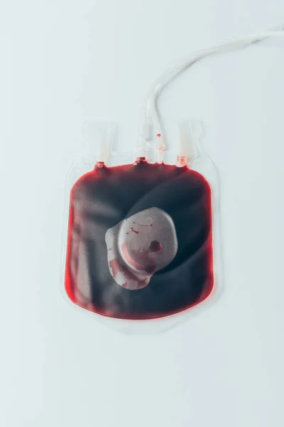 Vue du dessus du sac en plastique avec du sang pour transfusion sur table blanche — Photo de stock