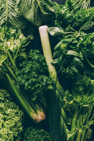 Вид на зеленые овощи и травы на столе — стоковое фото