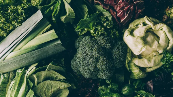 Vista superior de brócoli, puerro, col y diferentes verduras en la mesa - foto de stock