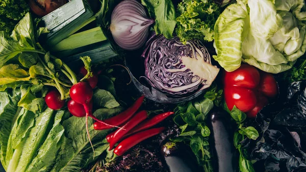Vista superior de la col roja, chiles, rábanos y diferentes verduras en la mesa - foto de stock