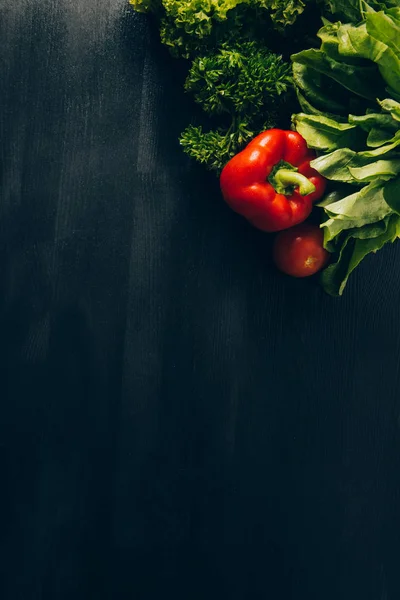 Vista dall'alto di peperone e insalata verde sul tavolo grigio scuro — Foto stock