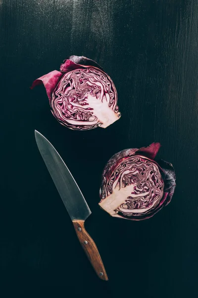 Vue du dessus du chou rouge coupé et du couteau sur la table sombre grise — Photo de stock