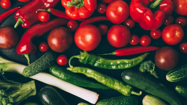 Vista superior de tomates, pimentas, pimentas e pepinos na mesa — Fotografia de Stock