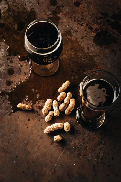 Vista superior do conjunto de mesa com amendoins e canecas de cerveja na superfície de ferrugem — Fotografia de Stock