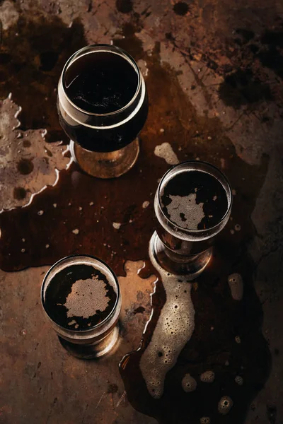 Top view of arranged mugs of beer on rust tabletop — Stock Photo
