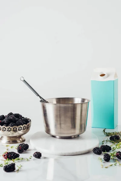 Vintage bowl of blackberries with metal bucket and whisk for cooking on white — Stock Photo