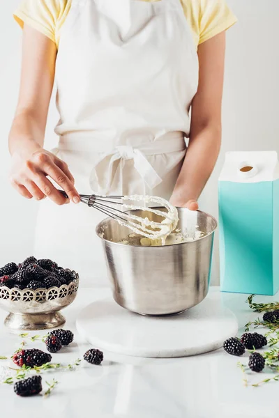 Tiro recortado de la mujer que prepara la crema para el pastel con batidor — Stock Photo