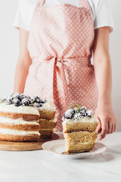 Cropped shot of woman serving delicious blackberry cake — Stock Photo