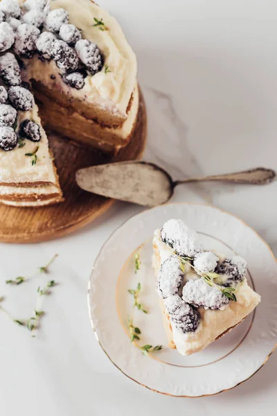 Крупным планом вкусный нарезанный ежевичный торт на деревянной доске с сервером тортов и на тарелке — стоковое фото