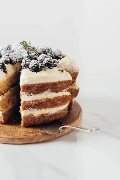 Close-up shot of delicious sliced blackberry cake on wooden cutting board with cake server — Stock Photo