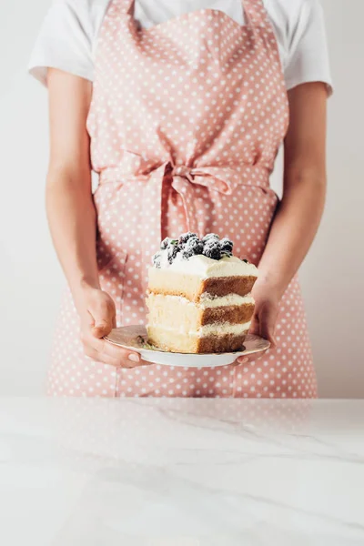 Colpo ritagliato di donna che tiene piatto con deliziosa torta di more — Foto stock