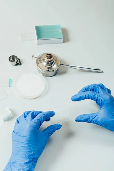 Image recadrée de scientifique en gants de latex examinant l'analyse dans un laboratoire moderne — Photo de stock