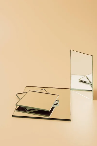 Pile of small mirrors on beige tabletop — Stock Photo