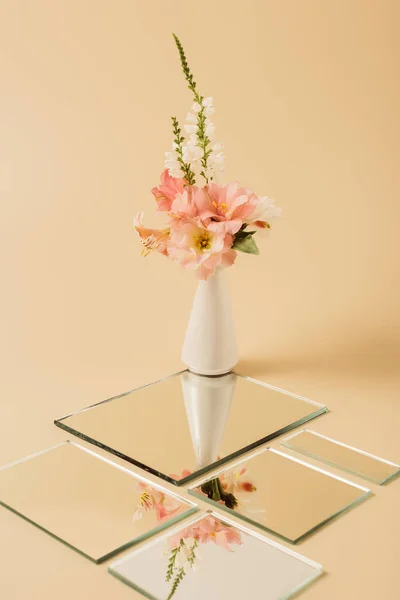 Lilienblüten in der Vase spiegeln sich in Spiegeln auf beigem Tisch — Stockfoto