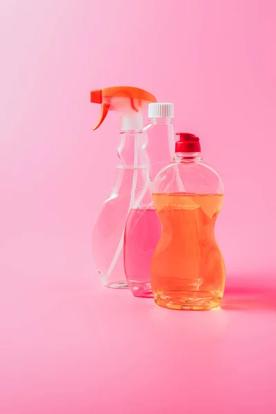 Close up view of dishwashing liquid and cleaning fluids, pink background — Stock Photo