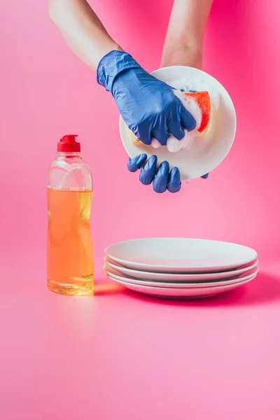 Imagem cortada de limpador feminino em placa de lavagem de luvas de borracha, fundo rosa — Fotografia de Stock
