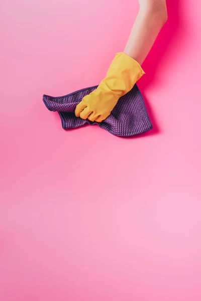 Обрезанное изображение женщины-уборщицы, вытирая пыль тряпкой, розовый фон — стоковое фото
