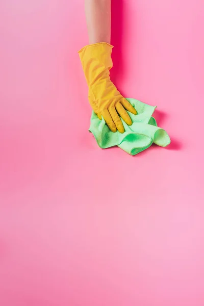 Vista parcial del limpiador hembra limpiando el polvo por trapo, fondo rosa - foto de stock
