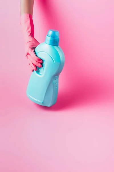 Cropped image of woman in rubber glove holding laundry liquid, pink background — Stock Photo