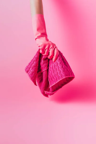 Partial view of female cleaner in rubber glove holding rag, pink background — Stock Photo