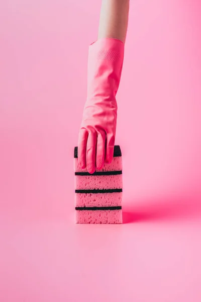 Cropped image of woman in rubber glove holding stack of washing sponges, pink background — Stock Photo