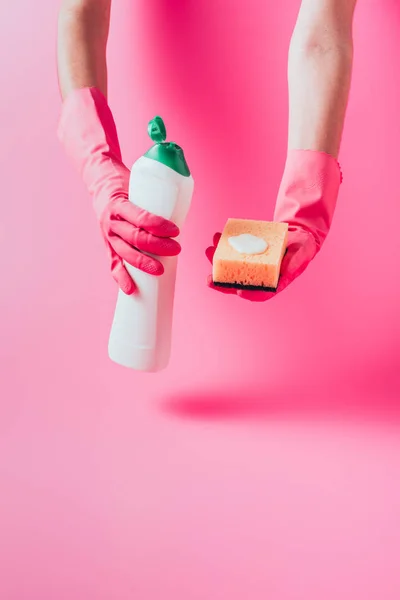 Обрезанное изображение женщины-уборщицы в резиновых перчатках с губкой для мытья и чистящей жидкостью — стоковое фото