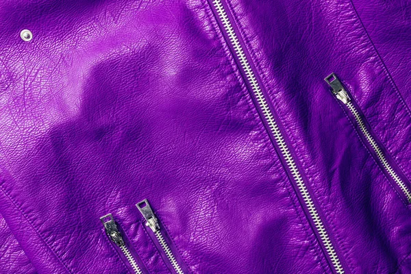 Top view of violet leather shiny textile with zippers as background — Stock Photo