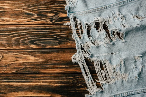 Top view of light denim textile on wooden tabletop — Stock Photo