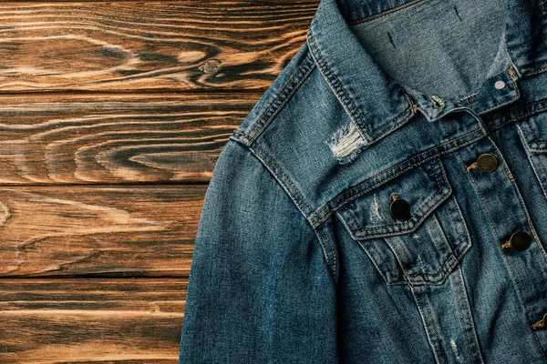 Top view of denim jacket on wooden table — Stock Photo