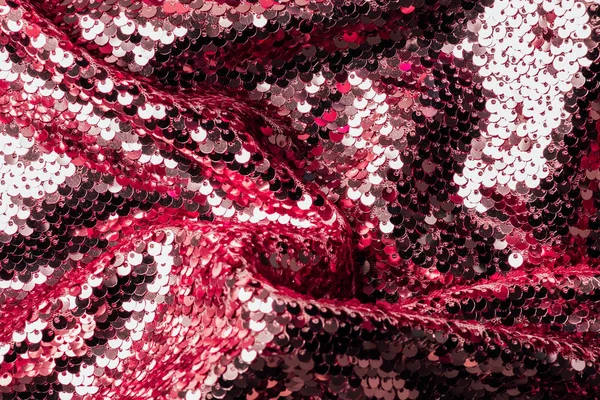 Vista superior de tecido iridescente vermelho e prata com lantejoulas brilhantes como fundo — Fotografia de Stock