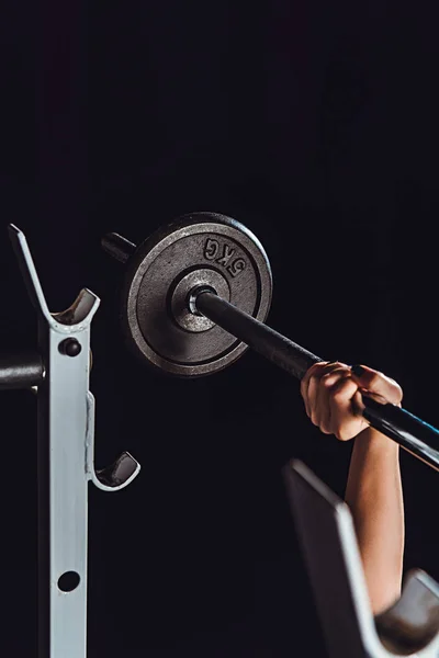 Image recadrée de bodybuilder femme faisant de l'exercice avec haltère à la salle de gym, fond noir — Photo de stock