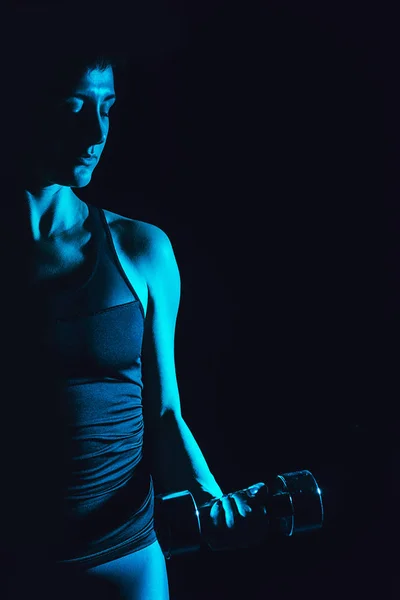 Immagine tonica di sportiva che fa esercizio con manubrio, sfondo nero — Foto stock