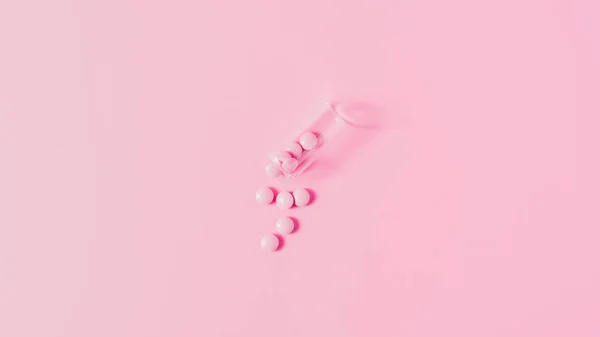 Vista superior dos medicamentos cor-de-rosa derramados do frasco sobre o tampo rosa — Fotografia de Stock