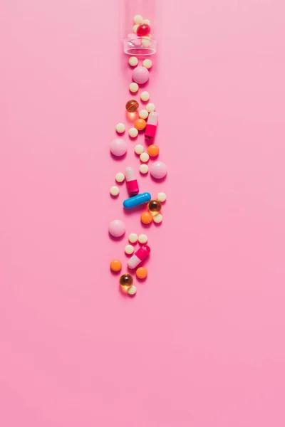 Vista superior de várias pílulas diferentes de garrafa em rosa — Fotografia de Stock