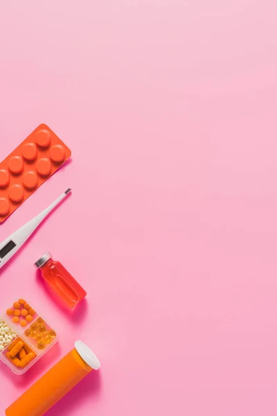 Draufsicht auf verschiedene Medikamente und elektrisches Thermometer auf rosa — Stockfoto