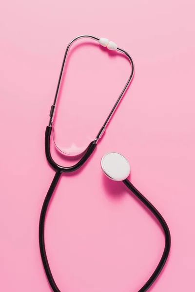 Top view of stethoscope lying on pink surface — Stock Photo